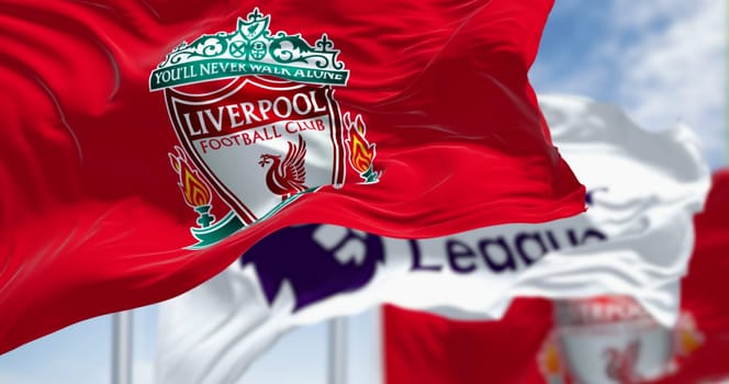 Liverpool, UK  seot. 14 2023: Liverpool Football Club and Premier League flags waving together on a clear day. Illustrative editorial 3d illustration render. Fluttering fabric. Selective focus
