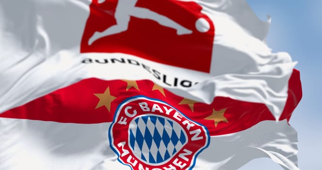 Munich, DE, Sept 10 2023: Bayern Munich flag waving with Bundesliga flag on a clear day. Professional german football club. Illustrative editorial 3d illustration render. Selective focus.