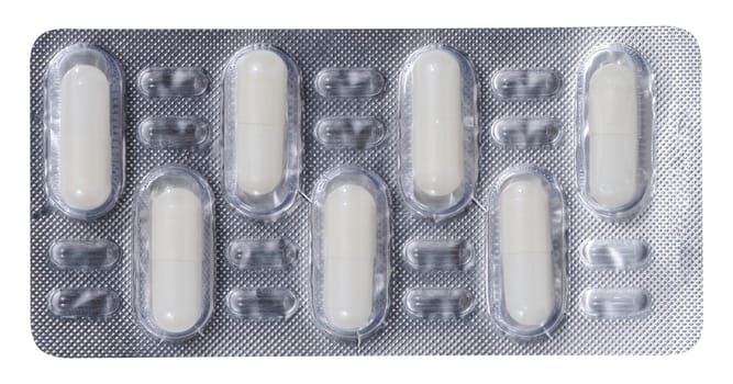 Oval white tablets in blister pack on a white isolated background, top view