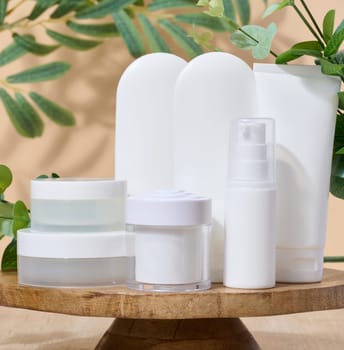 White plastic tubes and jar for cosmetic products on a white background, advertising and branding of products