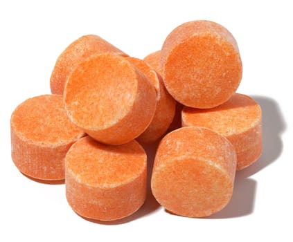 Round orange tablets on a white isolated background, vitamin C