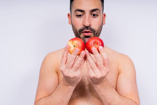 Man, hands and holding apple on white background in a studio for health, wellness or immune support.