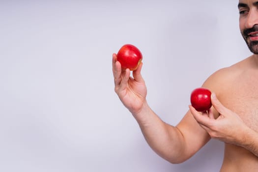 Man, hands and holding apple on white background in a studio for health, wellness or immune support.