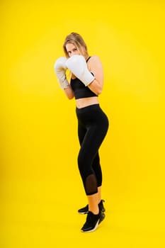 Female boxer hitting at boxing studio. Woman in gloves training hard.