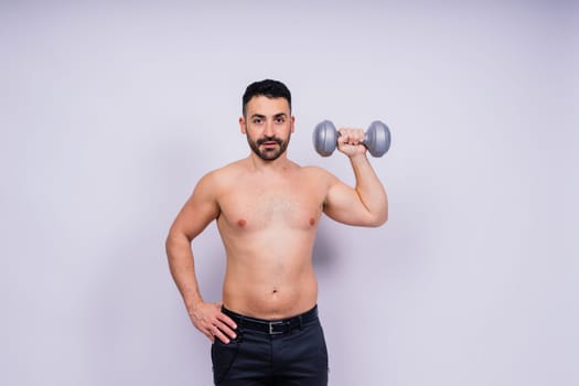 Athletic man doing exercises with dumbbell at biceps on a white background. Strength and motivation