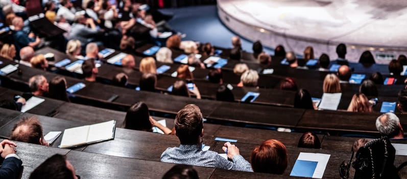 Business and entrepreneurship symposium. Audience in conference hall. Rear view of unrecognized participant in audience
