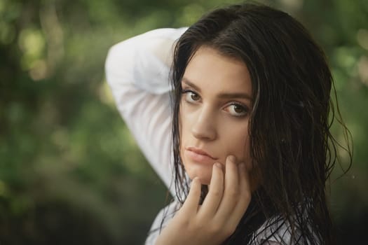 Closeup portrait of beautiful brunette girl posing with wet hair.  Horizontally.