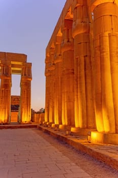 Night photo of illuminated columns of Karnak temple. (ancient Thebes). Luxor, Egypt. Vertically.