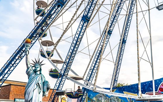 Ferris wheel with statue of liberty at the fairground on a beautiful summer day in germany.