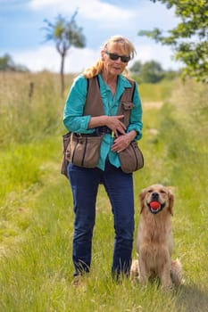 Woman wearing dummy vest and her obedient golden retriever