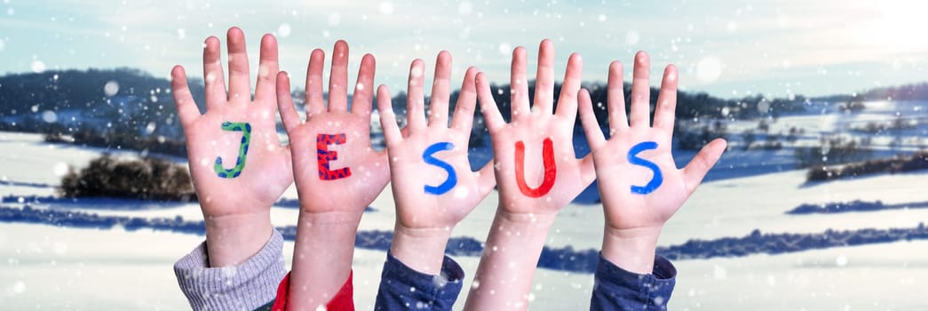 Children Hands Building Colorful English Word Jesus. White Winter Background With Snowflakes And Snowy Landscape.