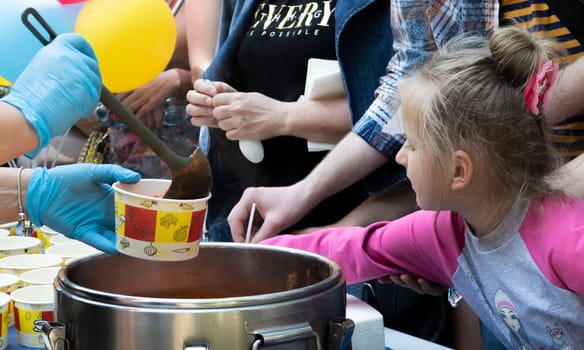 Tomato soup with pasta is a Polish dish. Zupa pomidorowa. Hot soup made from grated tomatoes. People and tourists walk, eat and buy food at the street food festival. Ukraine, Kyiv - August 17, 2023