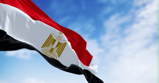 National flag of Egypt waving in the wind on a clear day. Horizontal red, white and black bands. Egyptian eagle emblem centered in white band. 3d illustration render. Fluttering fabric