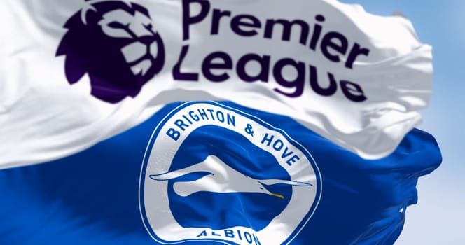 Brighton, UK, Aug. 23 2023: Brighton football club and Premier League flags waving in the wind on a clear day. Illustrative editorial 3d illustration render. Selective focus. Rippled fabric