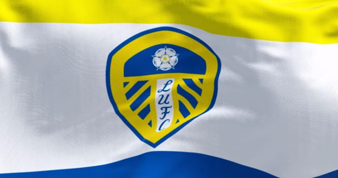 Leeds, UK, Sept 10 2023: Close-up of Leeds United flag waving. White shield with blue and yellow stripes, white rose, and LUFC in blue. Illustrative editorial 3d illustration render. Fabric background