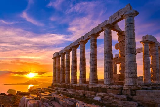Beautiful sunset sky and ancient ruins of temple of Poseidon, cape Sounio, Aegean sea coast, Greece. Travel destination of Athens area, important center of ancient Greek religion for Olympian Greek mythology, god of the sea and earthquakes,