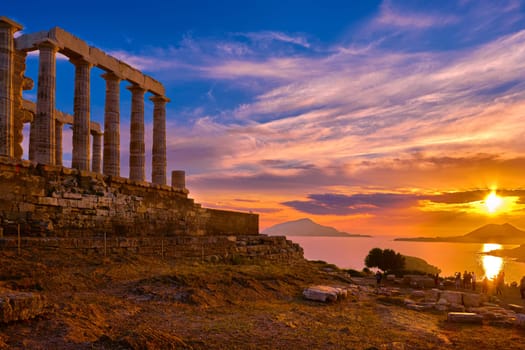 Beautiful sunset sky and ancient ruins of temple of Poseidon, cape Sounio, Aegean sea coast, Greece. Travel destination of Athens area, important center of ancient Greek religion for Olympian Greek mythology, god of the sea and earthquakes,