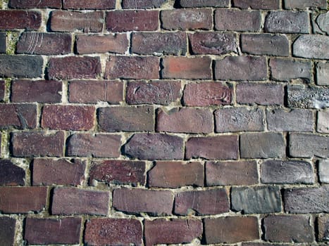 Full-format frontal view of a brick wall made of fired bricks.