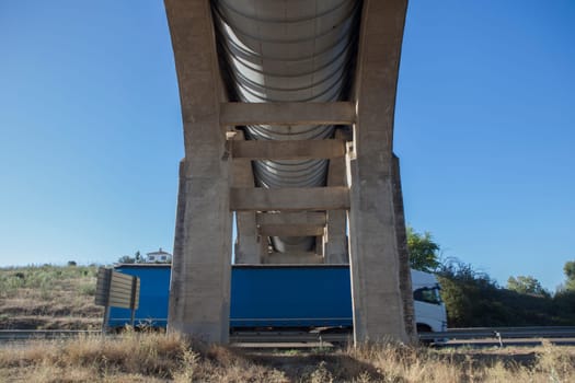 Truck crossing under Acedera Aqueduct through N430 National Road. Motion bluerred