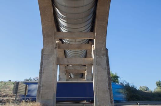 Truck crossing under Acedera Aqueduct through N430 National Road. Motion bluerred