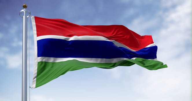 National flag of the Gambia waving in the wind on a clear day. Three horizontal red, blue, and green bands, separated by two narrow white bands. 3d illustration render. Fluttering fabric