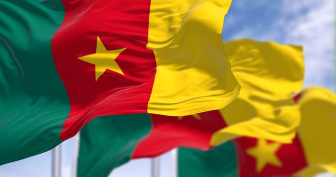Three Cameroon national flags waving in the wind. Three vertical stripes of green, red, and yellow, yellow star in the center. 3d illustration render. Fluttering fabric. Selective focus