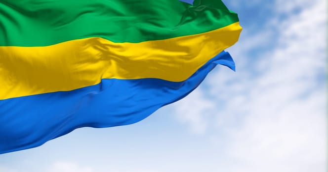 National flag of Gabon waving in the wind on a clear day. Three equal horizontal bands of green, yellow, and blue. 3d illustration render. Fluttering fabric