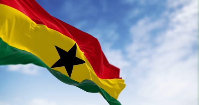 National flag of Ghana waving on a clear day. Three equal horizontal stripes, red, yellow with black star, green, pan-African colors. 3d illustration render. Fluttering fabric. Selective focus