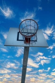 High bastkeball hoop with blue sky and white clouds