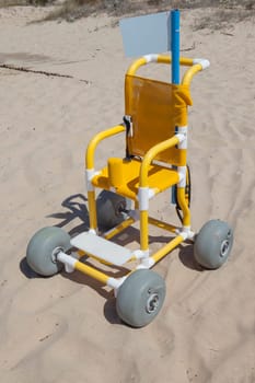 Children beach wheelchair on sand ready to use. Accessible tourism concept