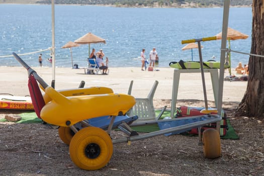 Beach wheelchair near reservoir shore ready to use. Accessible tourism concept