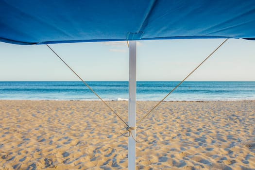 Awning structure with ocean as background. Beach trendy furniture concept