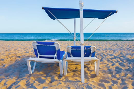 Awning structure and beah chair with ocean as background. Beach trendy furniture concept