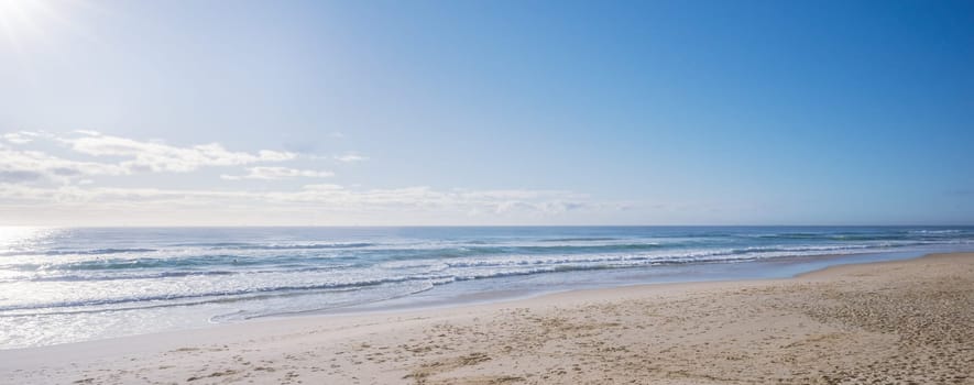 Soft pastel morning colors seascape as sun rises over ocean. Concept background for summer vacation or business travel. Inspirational beautiful relaxing scenery of seashore. Empty beach seascape with copy space.