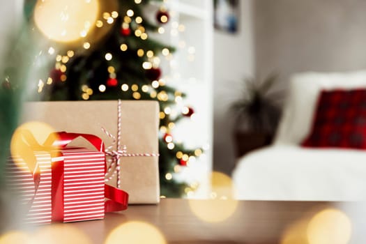 Christmas, New Year background with copy space for design. Empty wooden tabletop surface, blurred Christmas fir tree composition, bokeh sparkle lights effect. Mockup ready for product montage