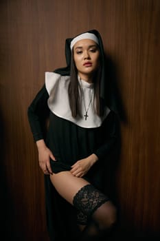 Beautiful sensual woman in nun robe seducing with passionate view showing perfect legs in sexual lingerie