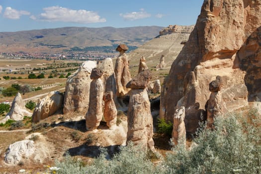 Unique geological rock formations Fairy Chimneys in Cappadocia against blue sky in summer. Popular touristic area in Goreme, Nevsehir, Turkey