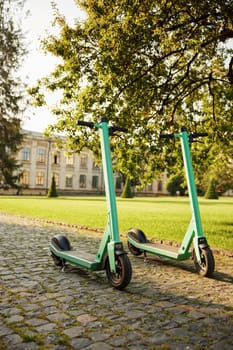 Eco-friendly electric scooter vehicles parked at university campus. Ecological transport for commuting, active recreation and healthy lifestyle