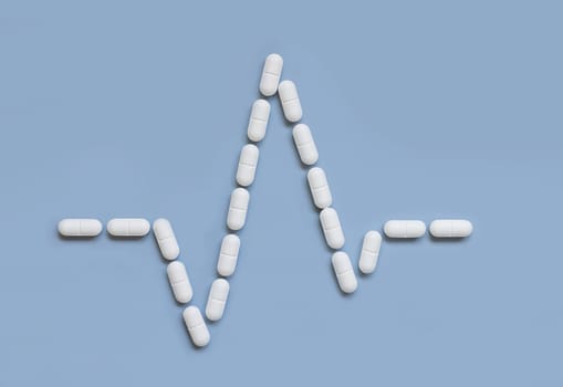 Heart rhythm cardiogram line made of white drug pills and capsules on light blue, top view. Pharmaceutical and cardiology concept, treatment of heart diseases.