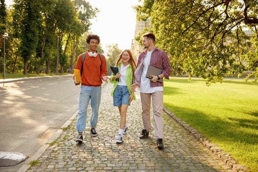 Casual diverse students chatting while walking and hanging out together during university campus break