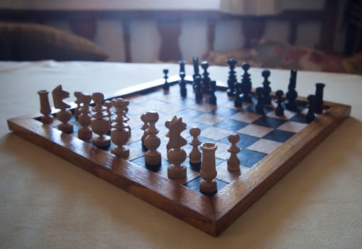 Wood turned chess board seen against the light. Cottage living room background