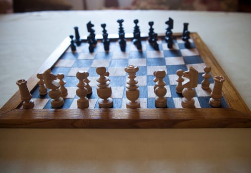 Wood turned chess board seen against the light. Cottage living room background