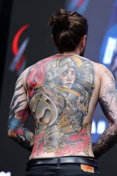 Krakow, Poland - June 11, 2022: Unidentified participant during the contest for the best tattoo at the 15th Tattoofest Convention in Cracow. One of the most prestigious tattoo festivals.