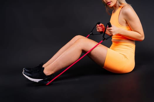 Blond woman with jump rope in a studio, yellow red and dark background