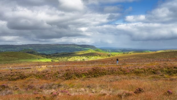 Woman standing on boardwalk and taking picture, photographing beautiful Cuilcagh Mountain, County Fermanagh, Northern Ireland