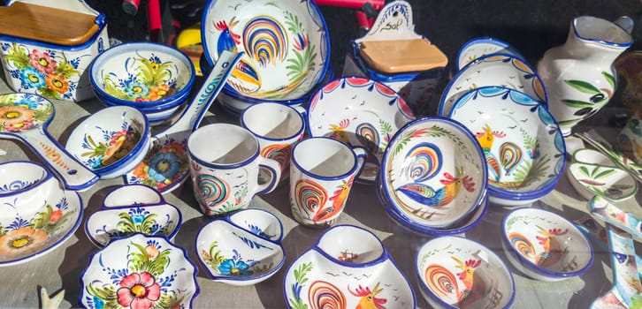 Vila Nova, Portugal - Jul 26th, 2023: Porcelain kitchenware porcelain painted with bright colors. Alentejo crafts