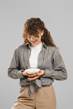 Smiling woman holds a plate full of pills in her hands