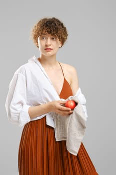 woman wiping an apple with a towel. Concept of healthy eating.