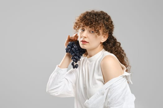 Studio portrait of woman with grape