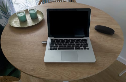 Living room table with laptop and eyeglasses case. Domestic workspace concept